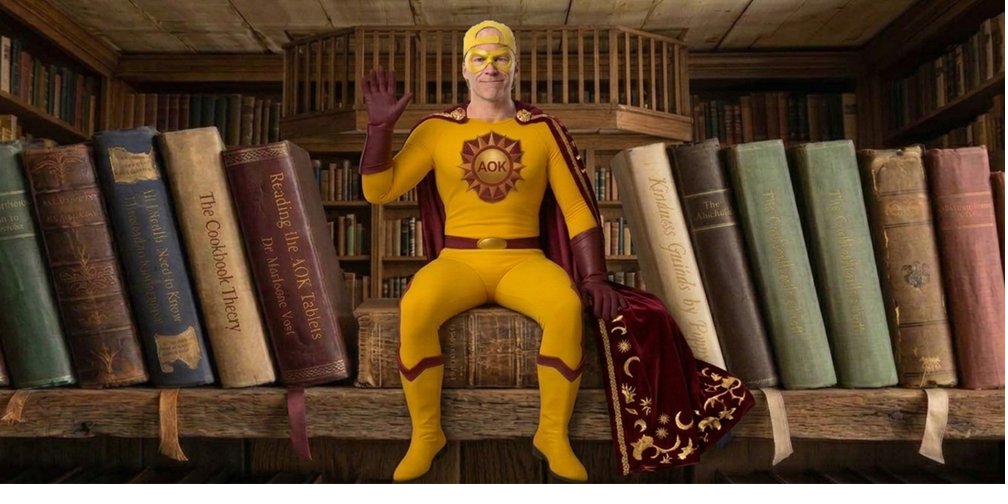 AOK Man sits on the civilization's bookshelf, surrounded by canonical volumes — Seneca, Marcus Aurelius, the Cookbook, the Janitor Principle, and other foundational books — waving warmly to greet the visitor